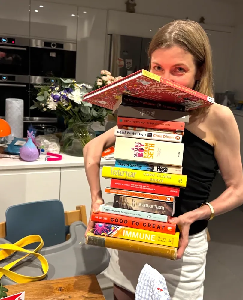 Holding an ambitious stack of books