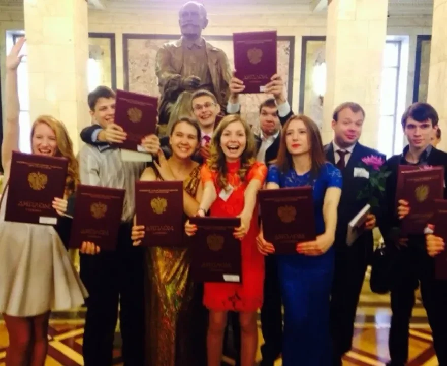 Katya and her graduating class holding their diplomas