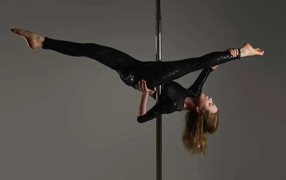 Practising a horizontal split on the pole