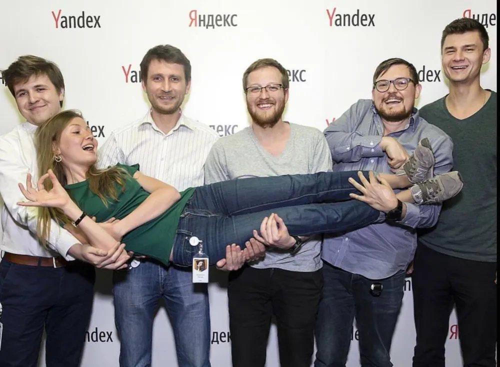 Katya being held up by smiling colleagues at Yandex