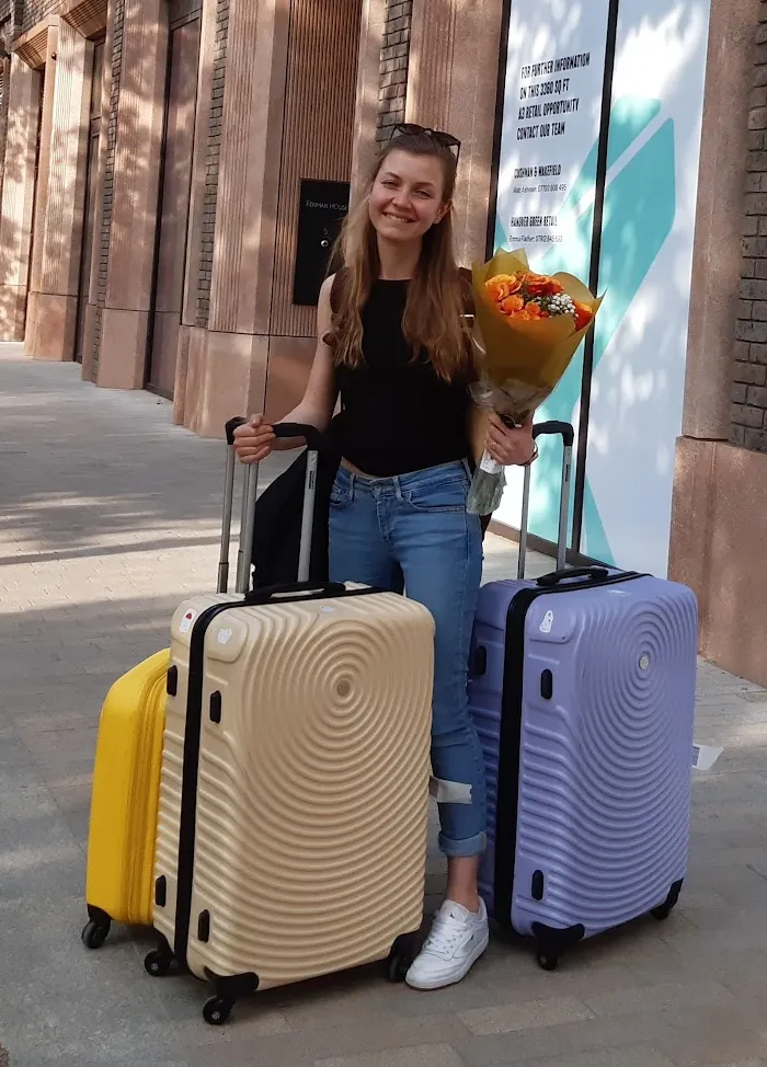 Katya with suitcases and flowers on her move to the UK